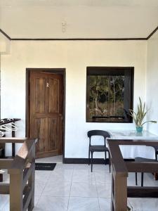 a room with a table and chairs and a wooden door at Zara's Casa Rental in Siquijor