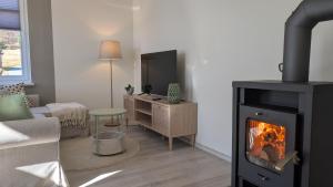 a living room with a fireplace and a living room with a couch at Oberlausitz Glück - gemütliche Ferienwohnung in ruhiger Lage mit Garten und Kamin in Sohland