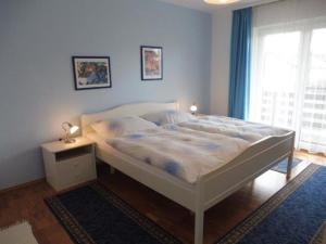 a bedroom with a white bed and a window at Ferienwohnungen Wennesz in Chieming