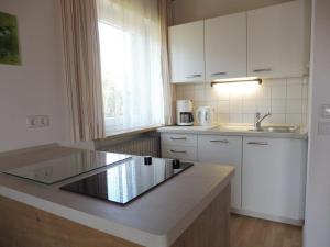 a kitchen with white cabinets and a counter top at Ferienwohnungen Wennesz in Chieming