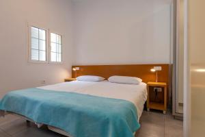 a bedroom with a large bed with a blue blanket at GC0284 El Granero in Mogán +7 photos