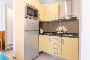 a kitchen with a stainless steel refrigerator and a microwave at GC0284 El Granero in Mogán