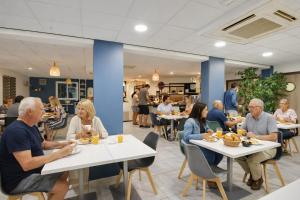 a group of people sitting at tables in a restaurant at Kyriad Perpignan Sud in Perpignan