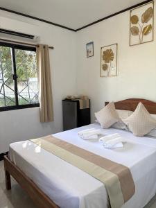 a bedroom with a bed with white sheets and a window at Zara's Casa Rental in Siquijor