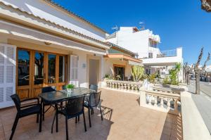a patio with a table and chairs and a building at YourHouse Casa Rafael in Can Picafort