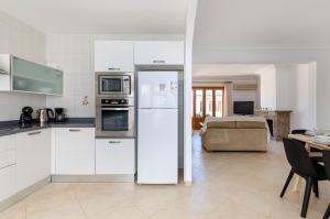 a kitchen with a refrigerator and a living room at YourHouse Casa Rafael in Can Picafort