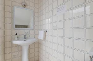 a white tiled bathroom with a sink and a mirror at YourHouse Casa Rafael in Can Picafort +28 photos