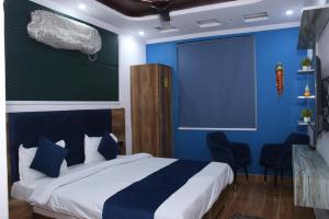 a bedroom with a bed with blue walls and chairs at Red Leaf Hotel in Māler Kotla