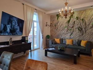 a living room with a couch and a large painting on the wall at Lovran deluxe apartman in Lovran