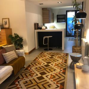 a living room with a couch and a rug at Maré do Bairro Studio Beira Mar Aveiro in Aveiro