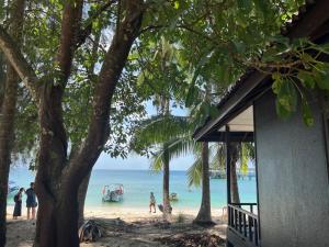 a beach with a house and people on the beach at Maya Seaview Chalet, Coral Bay Perhentian Island in Perhentian Island
