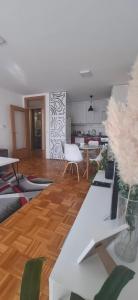 a living room with white furniture and a kitchen at Apartman Stella Istočno Sarajevo in Lukavica