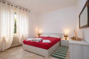 a bedroom with a red bed and a window at Casa Curti 1 in Sorico +7 photos