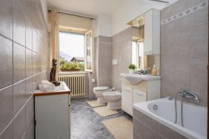 a bathroom with a tub and a toilet and a sink at Casa Curti 1 in Sorico