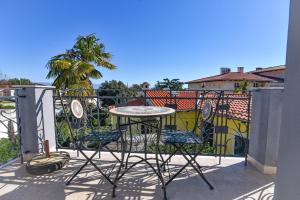 a patio with a table and chairs on a balcony at Lovran deluxe apartman in Lovran