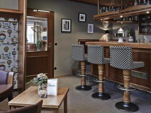 a bar in a restaurant with a table and chairs at DORMERO Hotel Crailsheim in Crailsheim