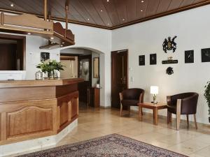 a lobby with a bar and two chairs and a table at DORMERO Hotel Crailsheim in Crailsheim