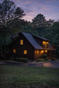 a log cabin with its lights on in the night at Wilderness retreat in Marion