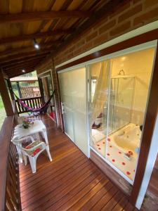 a balcony with a tub and a chair on a porch at Chalés Aguas Serenas in Santo Antônio do Pinhal +161 photos