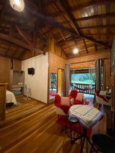 a living room with a couch and a bed at Chalés Aguas Serenas in Santo Antônio do Pinhal