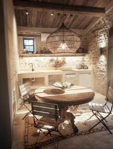 a kitchen with a table and chairs and a sink at Moulin des Bergères in Mouriès