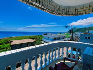 a balcony with chairs and a view of the ocean at Yabiya home stay in Lanyu