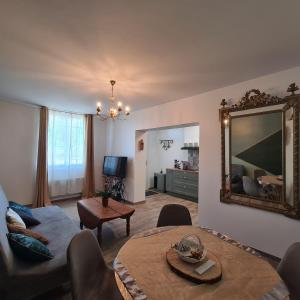 a living room with a couch and a mirror at Joli Eden in Saint-Sulpice-de-Faleyrens