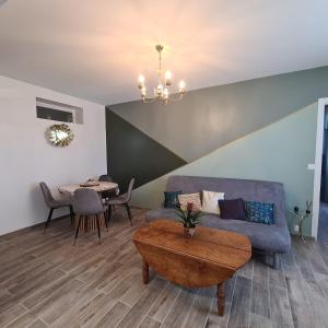 a living room with a couch and a table at Joli Eden in Saint-Sulpice-de-Faleyrens