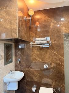 a bathroom with a sink and a toilet and a shower at Pacific Grand in Amritsar +52 photos
