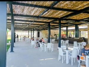 a restaurant with white chairs and tables and people sitting at tables at Villa PALA in Kemer
