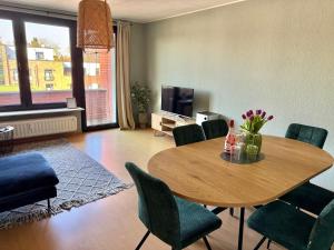 a living room with a wooden table and chairs at Schöne 3-Zimmer City-Wohnung in Neumünster