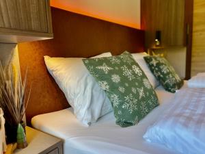 a bed with two green pillows on top of it at Almchalet Alpenglück in Sankt Lambrecht +55 photos