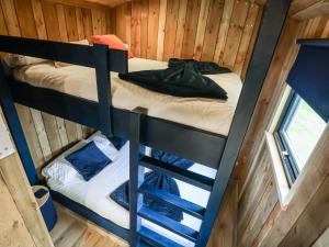 two bunk beds in a cabin with a window at The Suffolk Hut in Knutsford