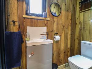 a bathroom with a sink and a toilet and a clock at The Suffolk Hut in Knutsford +25 photos