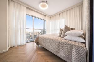 a bedroom with a bed and a large window at Savyon View Tower - Isrentals in Jerusalem
