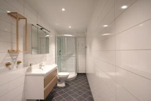 a white bathroom with a toilet and a sink at Arctic City Suites 2 in Kirkenes +17 photos