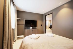 a bedroom with a bed with two towels on it at Arctic City Suites 2 in Kirkenes