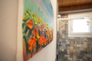 a painting of flowers is hanging on a wall at B&B Basta Bussare in Chioggia +107 photos