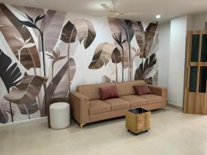 a living room with a couch and a flower mural at Backwoods inn in Heggadadevankote