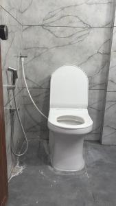 a bathroom with a white toilet and a shower at Backwoods inn in Heggadadevankote