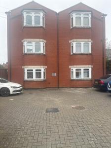 a large red brick building with white windows at Golden Stay in Wyken