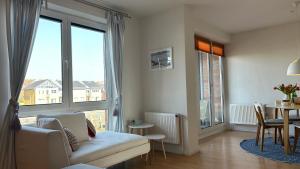 a living room with a couch and a table and windows at Simmerdeis am Hafen in Husum +26 photos