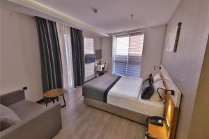 ein Hotelzimmer mit einem Bett und einer Couch in der Unterkunft Buca Mat Hotel By Tahtalı in Izmir