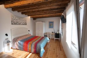 a bedroom with a bed and a desk in a room at B&B Basta Bussare in Chioggia