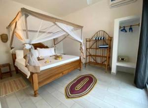 a bedroom with a large bed with a canopy at TWIGA APARTHOTEL by Sofia Collection in Pwani Mchangani