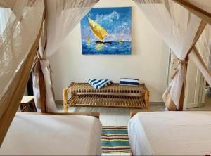 a bedroom with two beds and a painting on the wall at TWIGA APARTHOTEL by Sofia Collection in Pwani Mchangani