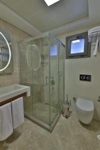 ein Badezimmer mit Glasdusche und Toilette in der Unterkunft Buca Mat Hotel By Tahtalı in Izmir