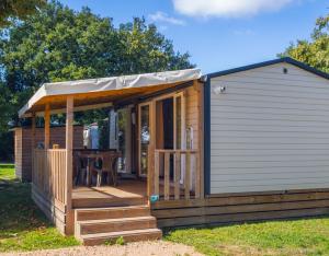 a cabin with a deck with a table at L'Oasis des Dombes in Ambérieux-en-Dombes
