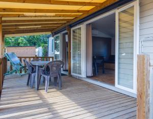 a patio with a table and chairs on a deck at L'Oasis des Dombes in Ambérieux-en-Dombes +14 photos
