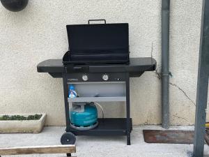 a barbecue grill sitting on the sidewalk next to a wall at Au Vingt Neuf in Loches